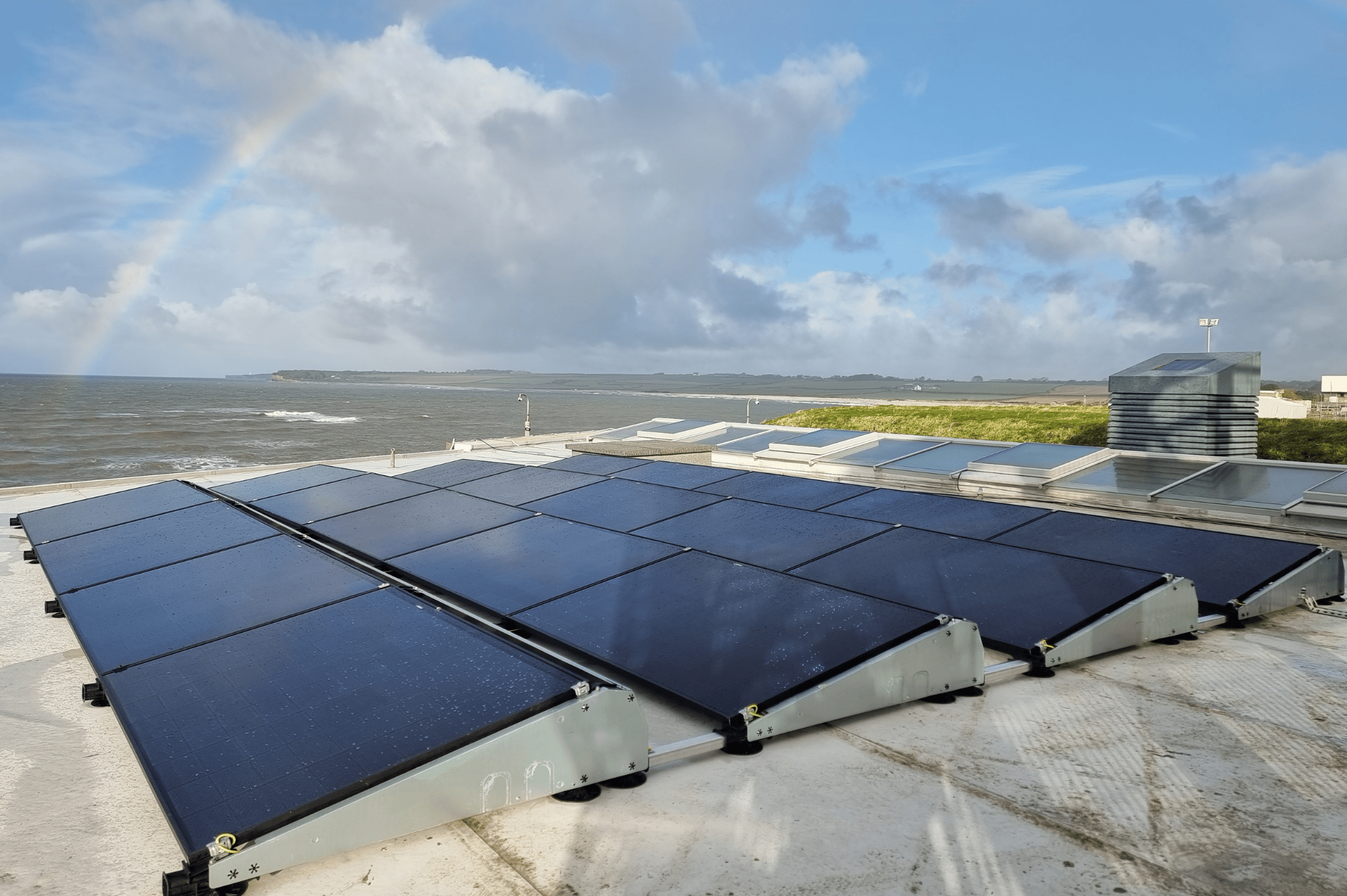 Solar panels on the roof of commercial premises, looking over the coastline.